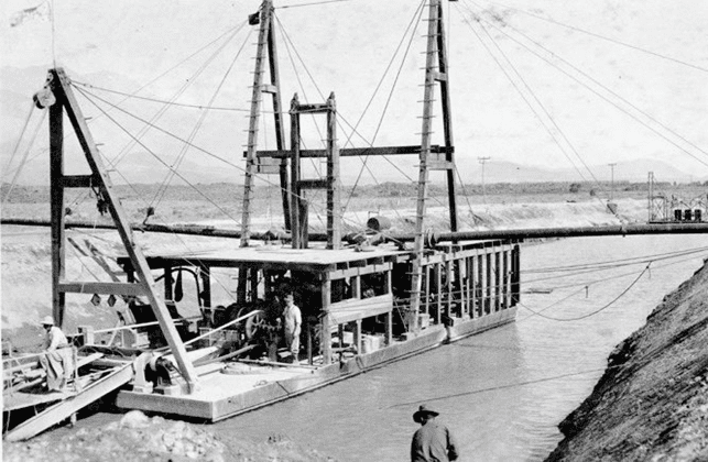 (1908)^#^ - Dredge No 1 in 1908. The dredge got its power through electric lines running from nearby Cottonwood Power Plant.