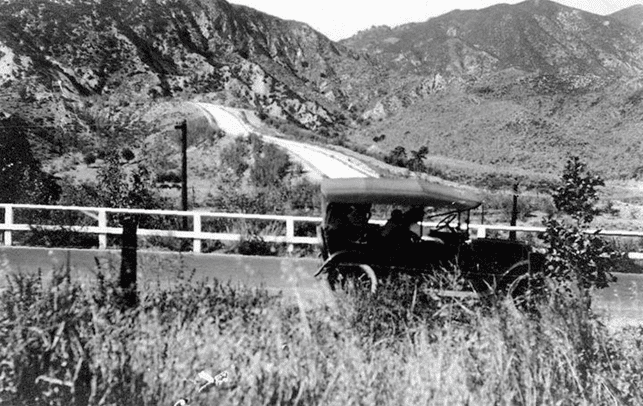 (ca. 1920s)^.^ – An early model car stops in front of the Los Angeles Aqueduct Cascades.